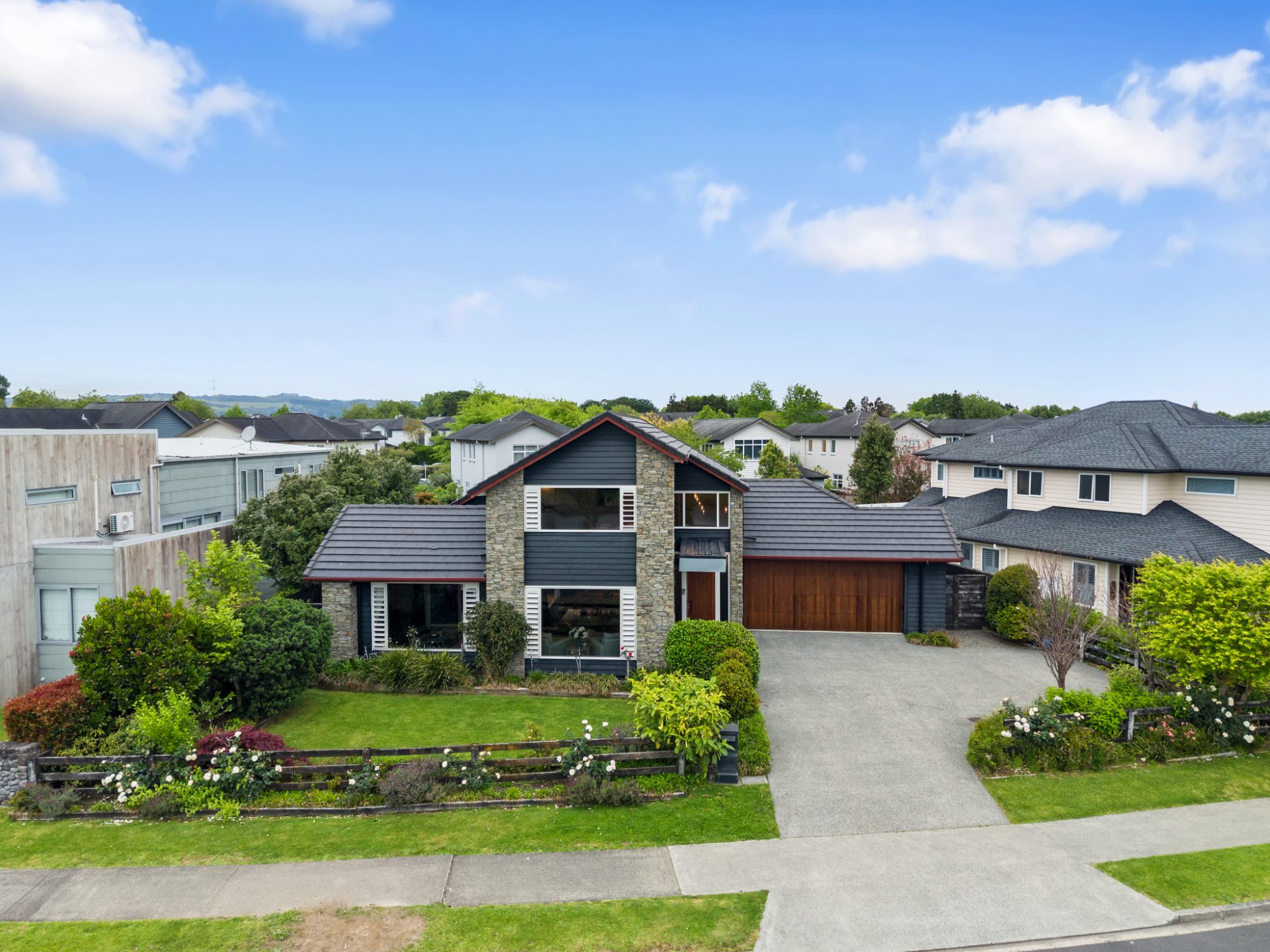 Aerial view of a two-storey family home and garden in Karaka