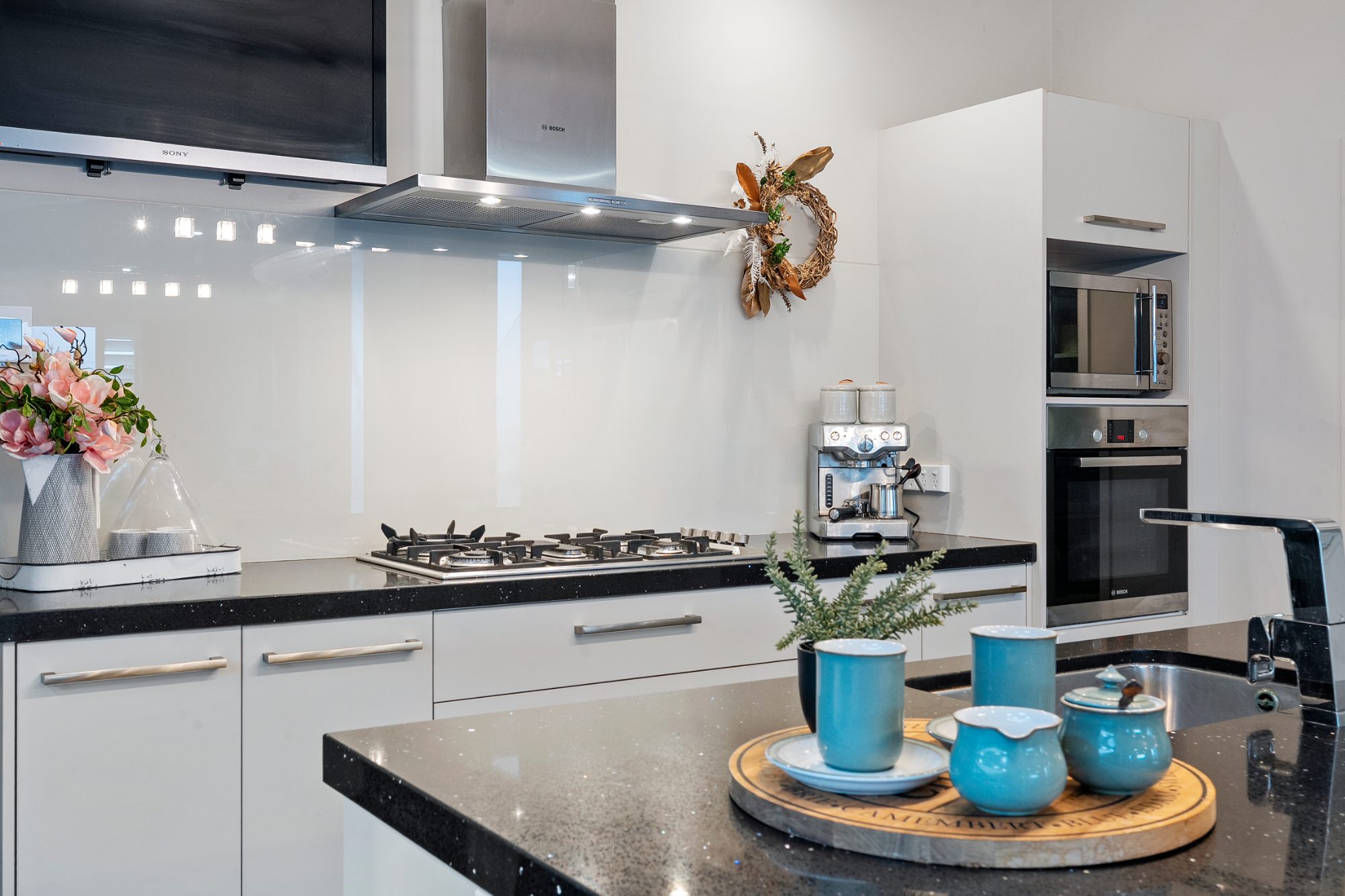Kitchen with stone benchtop and styled detail in a Karaka home
