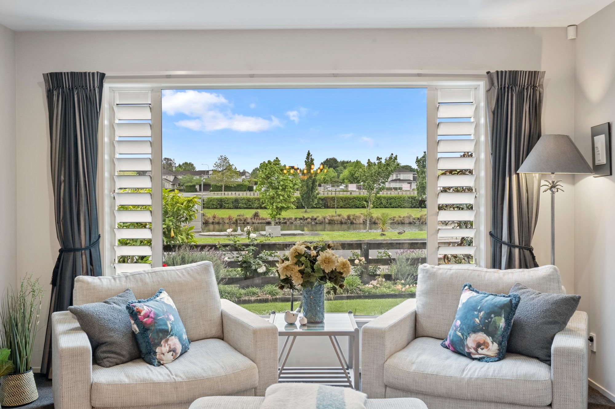 Living room in a Karaka home with a wide outlook over green fields
