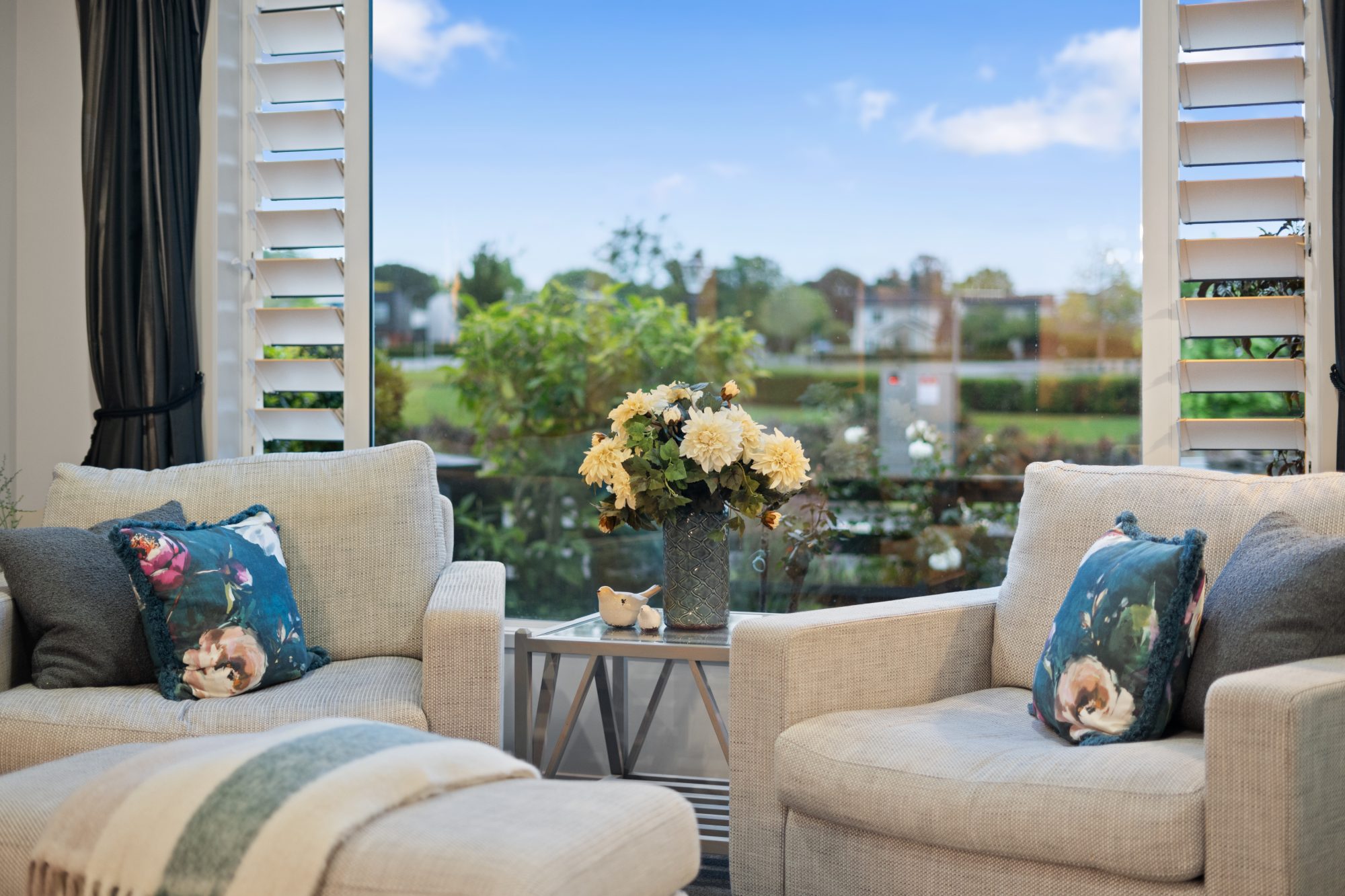 Sitting area with armchairs and a rural outlook in a Karaka home