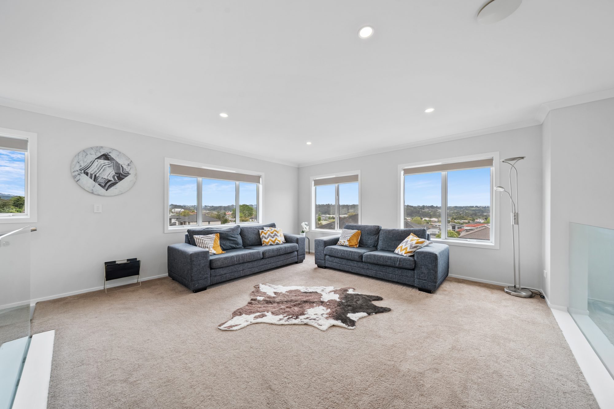 Upstairs living room with large windows in a Ranui home