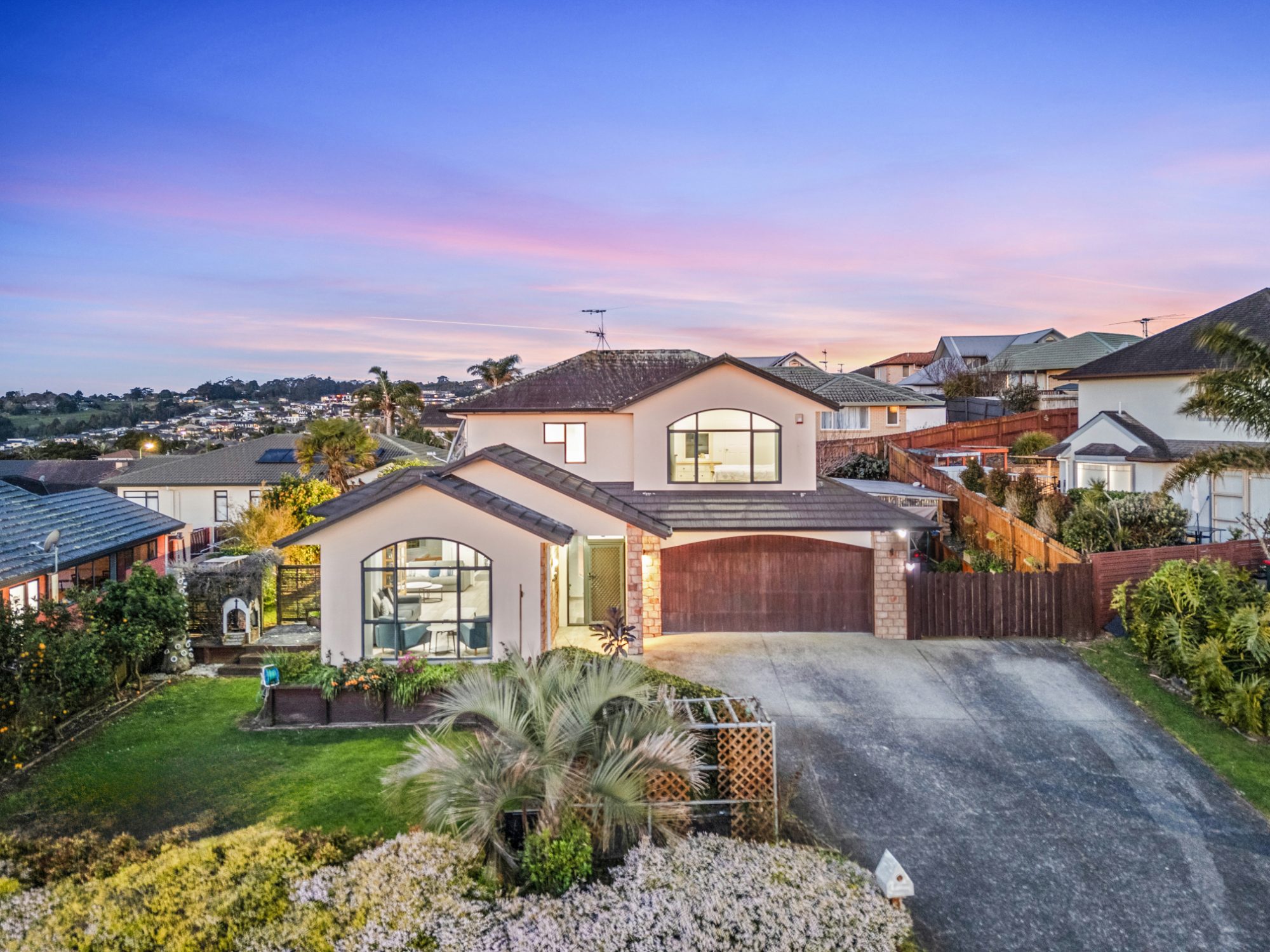 Twilight aerial of a home in The Gardens with the street and neighbourhood behind